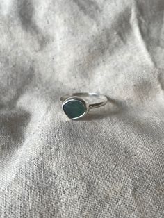 Handmade sterling silver Sea glass ring, made with recycled silver, and genuine Sea glass from the jurassic coast.  This ring has one small piece of turquoise sea glass, and is very dainty and elegant. The ring is also stackable, especially with the other sea glass rings i have listed! This ring is a perfect gift for special occasions, and for Sea glass lovers!  The ring is size UK Y 1/2 .  All of the silver on the ring is 925 Sterling Silver, including the band! Feel free to message me for any additional information, or for commissions/custom requests! Sea Glass Rings, Sea Glass Ring, Jurassic Coast, Silver Sea, Glass Ring, Jewellery Gifts, For Her Gifts, Glass Rings, Recycled Silver