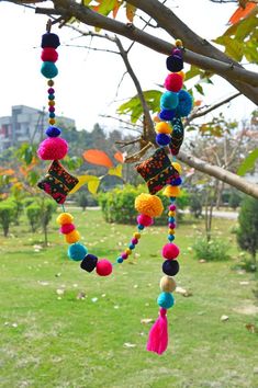 a colorful mobile hanging from a tree in a park