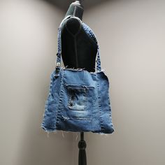 "Upcycled denim shoulder bag with frayed seams, exterior pockets and denim waistband shoulder strap. 15\" wide, 14\" high and shoulder strap measures 32\"." Denim Shoulder Bag, Upcycled Bag, Denim Tank, Denim Shoulder Bags, Knit Infinity Scarf, Upcycled Denim, Denim Patchwork, Canvas Handbags, Casual Tote