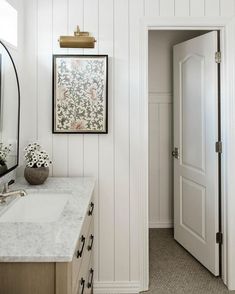 a bathroom with white walls and marble counter tops