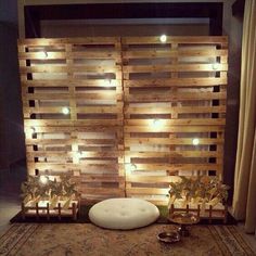 a bed made out of pallet wood with lights on it and plants in the middle