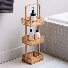 a bamboo shelf with soap and lotion bottles on it next to a bathtub