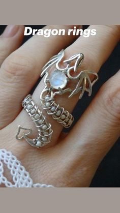 a woman's hand with a ring on it and the words dragon rings written in silver