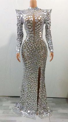 a mannequin is dressed up in a silver dress with long sleeves and high slits