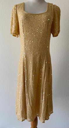 Stunning, fully lined silk dress adorned with ornate beadwork and sequins. This is a rare style for the Judith Ann label as it has a more fitted and tailored silhouette. Elegant and wearable. Back zipper with hook and eye. Chest - 37 Shoulders - 15 Waist - 31 Length - 39 It is in excellent vintage condition, no flaws. Please check all photos and descriptions carefully, and please contact me with questions.  We will issue refunds, but only if an item is damaged, or faulty, or not as described on the listing. Thanks so much for looking! Elegant Gold Embellished Sequin Fabric, Vintage Gold Sequin Dress, Vintage Summer Embellished Sequin Dress, Luxury Gold Embellished Sequin Fabric, Elegant Gold Beaded Sequin Fabric, Silk Dress, Vintage Gold, Dress Clothes For Women, Bead Work