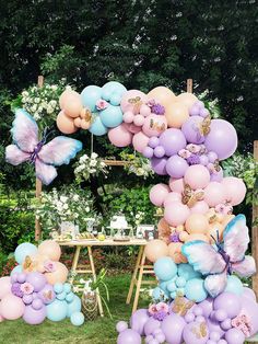 a bunch of balloons that are in the shape of a butterfly on a table outside