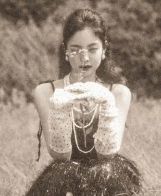 a woman sitting on top of a grass covered field