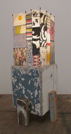 a wooden table topped with a sculpture made out of different types of fabric