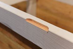 a piece of wood sticking out of the side of a window sill that is partially painted white