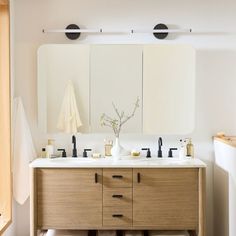 a bathroom with two sinks and mirrors in it