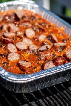 a metal pan filled with food sitting on top of a grill