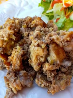 a close up of food on a plate near a salad