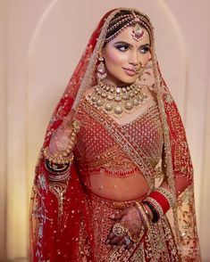 a woman in a red and gold bridal outfit