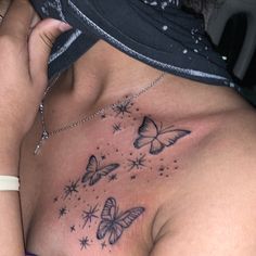 a woman's chest with butterflies and stars tattooed on her left side ribcage