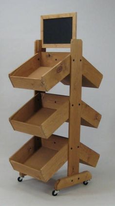 a wooden shelf with chalkboard on top and wheels attached to the bottom, in front of a white background