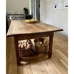 a wooden table with baskets on top of it and an oven in the back ground