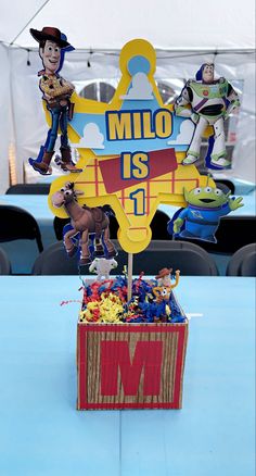 a toy story themed centerpiece is displayed on a table in front of a tent