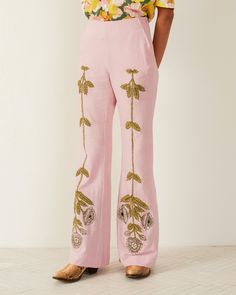 A person is wearing the Charlie Crocus Embroidered Pant in light pink silk, featuring intricate hand-embroidered floral motifs, and stands with their hands in the pockets. They are also sporting a partially visible floral top and brown shoes. The setting seems to be indoors with a light-colored floor and wall backdrop. Pink Pant, Alix Of Bohemia, Shooting Ideas, Embroidered Pants, Pink Pants, Girls Wardrobe, Silk Pants, New Arrival Dress, 70s Fashion