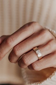 a woman's hand with a wedding ring on it