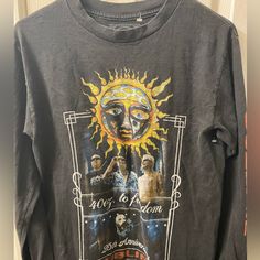 a black shirt with an image of the sun and two men's faces on it