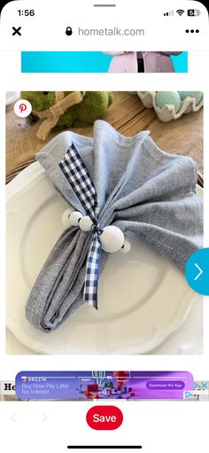 a white plate topped with a gray napkin and a bow tie on top of it