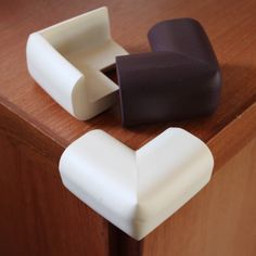 two pieces of chocolate sitting on top of a wooden counter next to an object that looks like a heart