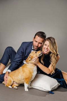 a man and woman sitting on the floor with their dog