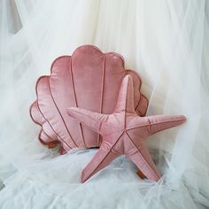 a pink starfish pillow sitting on top of a bed