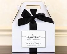 a white box with a black ribbon and welcome sign