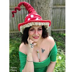 a woman wearing a red and white crocheted hat with a dragon on it