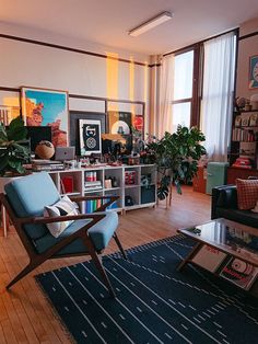 a living room filled with furniture and lots of plants on top of it's shelves