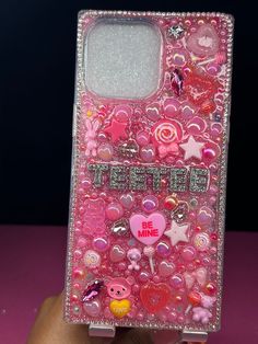 someone is holding up a pink case with many different things on it and the words be mine