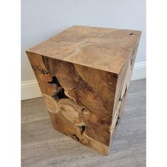 a wooden box sitting on top of a hard wood floor next to a white wall