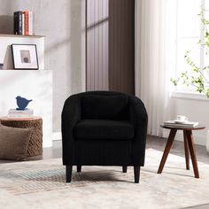 a black chair sitting on top of a rug in a living room