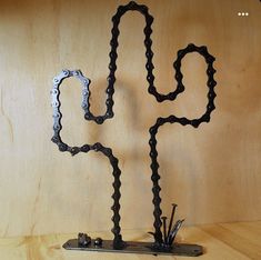 a sculpture made out of chains on a wooden surface