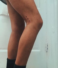 a woman's legs with small tattoos on her left leg and the bottom part of her thighs