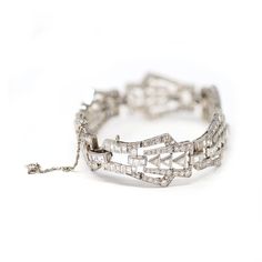 Art Deco platinum and diamond bracelet, designed as a series of openwork geometric links set throughout with various-cut diamonds weighing approximately 9 carats, GH color VS clarity. The gross weight is 37.2 grams, length 7 ⅛ inches, width ¾ inch. Art Deco Diamond Bracelet In White Gold, Art Deco Silver Diamond Bracelet With Brilliant Cut, Art Deco White Gold Diamond Bracelets, Silver Art Deco Diamond Bracelet With Brilliant Cut, Art Deco Platinum Silver Tennis Bracelet, Art Deco Platinum Diamond Bracelet, Silver Brilliant Cut Diamond Bracelet In Art Deco Style, Art Deco Diamond Jubilee Bracelet, Art Deco Style Formal Cubic Zirconia Diamond Bracelet