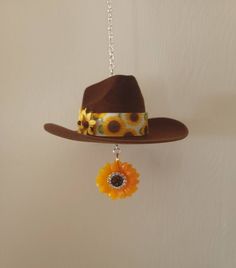 a brown hat with sunflowers hanging from it's side on a chain