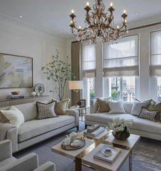 a living room filled with lots of furniture and a chandelier hanging from the ceiling