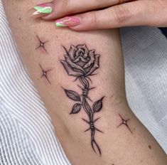 a woman's arm with a rose tattoo on it