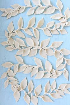 some white leaves are on a blue tablecloth and it looks like they have been made out of clay