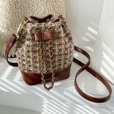 The EMES SHOP bag details a woven tweed-like material into a small basket shape. Features an adjustable string in the front and a removable strap. this satchel is the perfect fit for your summer outfits.MATERIAL:100% Vegan Leather & PolyesterMEASUREMENTS:H" X W"X D" 17.5cm X 18.5cm X 9cm 6.9in X 7.3in X 3.5in Shop Bag, Luxury Clutch, Small Basket, Professional Bag, Lowest Price, Color Matching, Bucket Bag, Vegan Leather, Clutch Bag