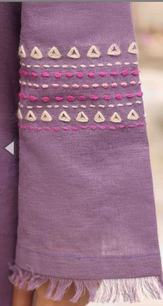 a close up of a purple cloth with pink and white designs on it's side