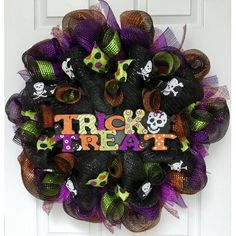 a halloween wreath that says trick or treat on the front door with skulls and bones