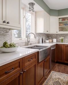 a kitchen with wooden cabinets and white counter tops, along with an area rug on the floor