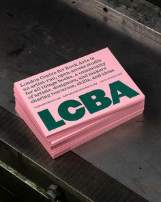 a stack of pink cards with the words loba printed on them sitting on top of a piece of wood