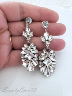 a pair of earrings is being held in someone's hand