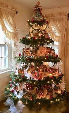 a christmas tree decorated with houses and lights