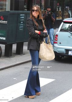 a woman is crossing the street with her purse