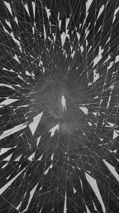 an abstract black and white photo with lots of lines in the center, as well as a person walking through it